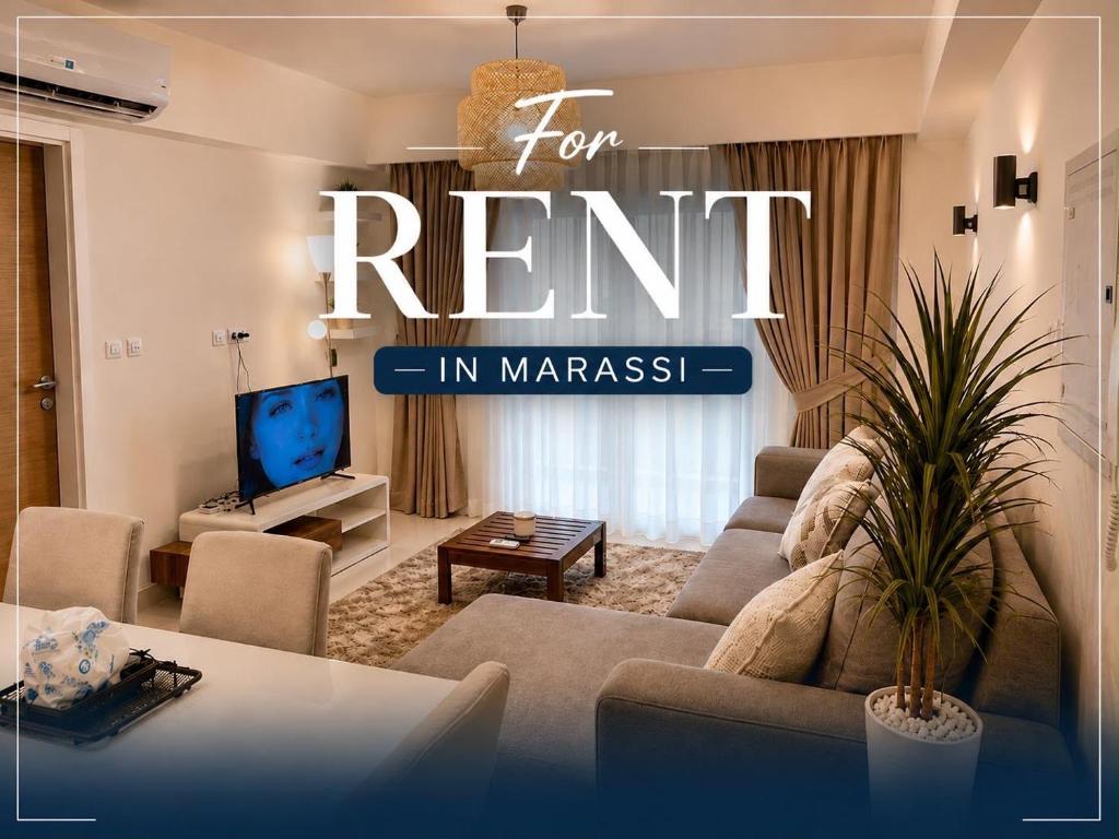 a living room with a couch and a tv at Chalet with garden-marassi marina 2- Pool View in El Alamein