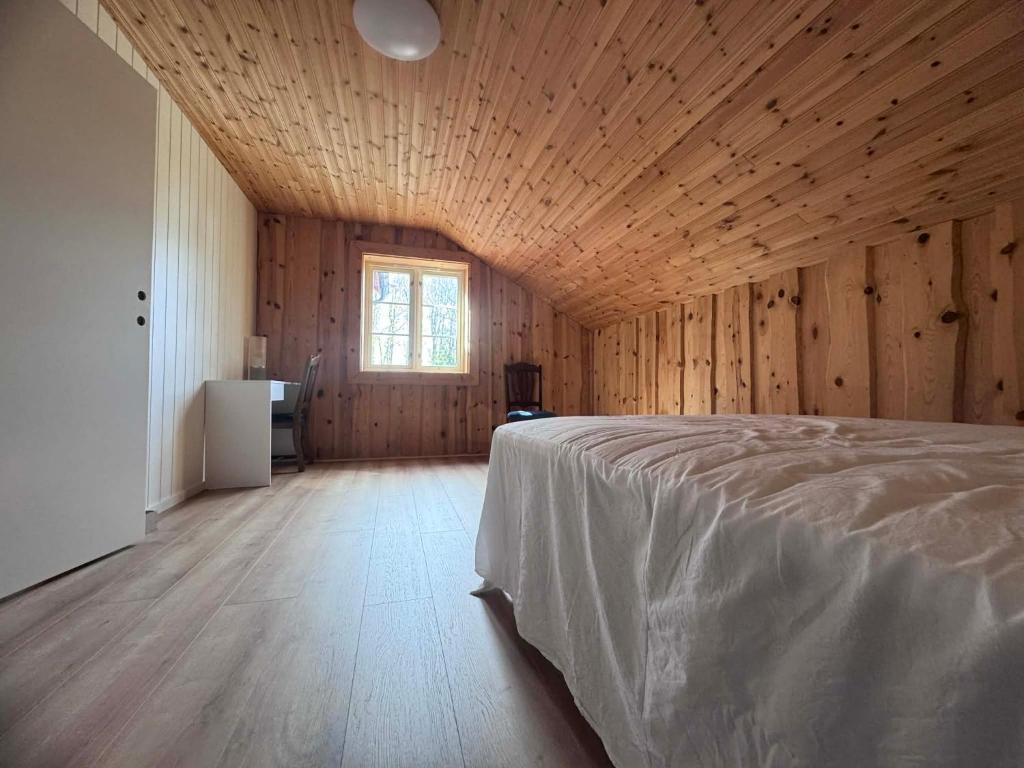 a bedroom with wooden walls and a bed in a room at Grefstadvigveien 12 in Grimstad