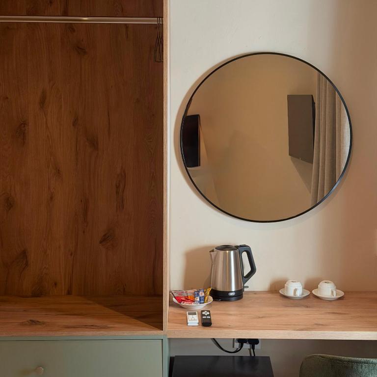 a mirror on a wall above a table with a coffee pot at Thatch Haven in Mahikeng
