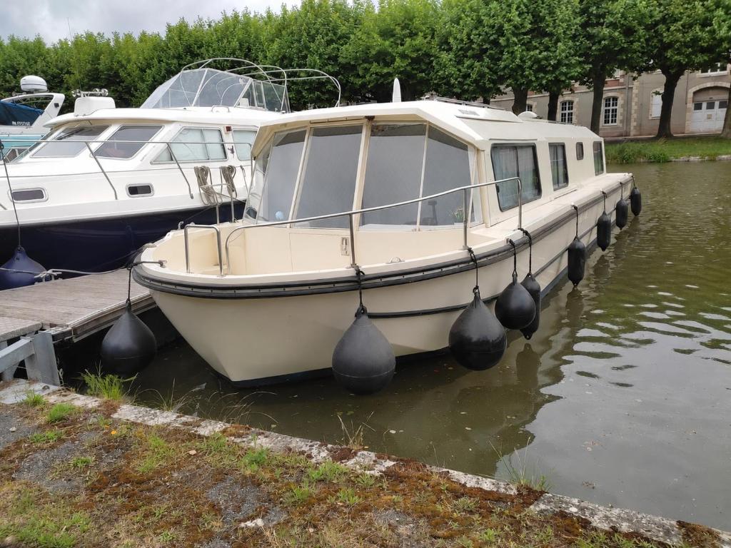 a boat is docked at a dock in the water at Rem'Ann boat in Briare