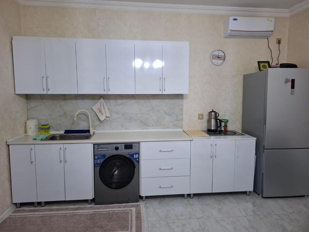 a kitchen with white cabinets and a washing machine at 2-Room Modern House in Naxçıvan