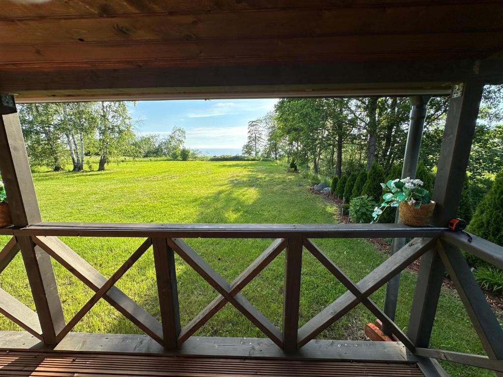 a view of a field from the porch of a cabin at Vienmerjura in Benuži