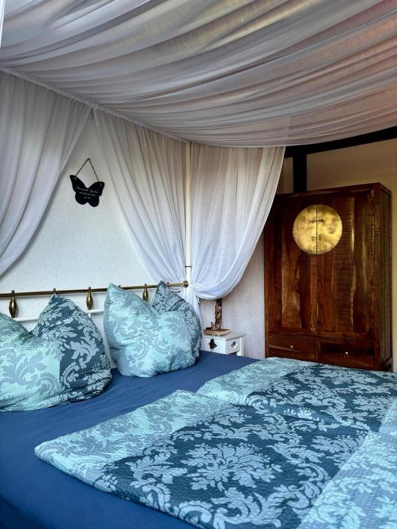 a bedroom with a bed with blue comforter and pillows at Amselhof Kördorf in Kördorf