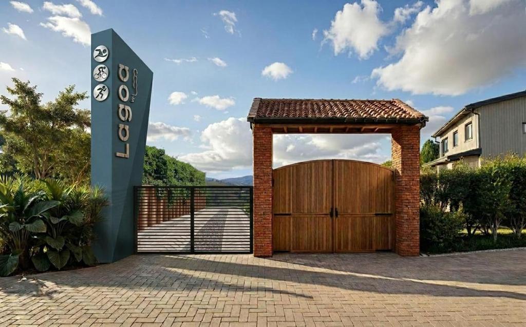 a garage with a wooden door and a gate at Lagoa by Loop in Horizonte