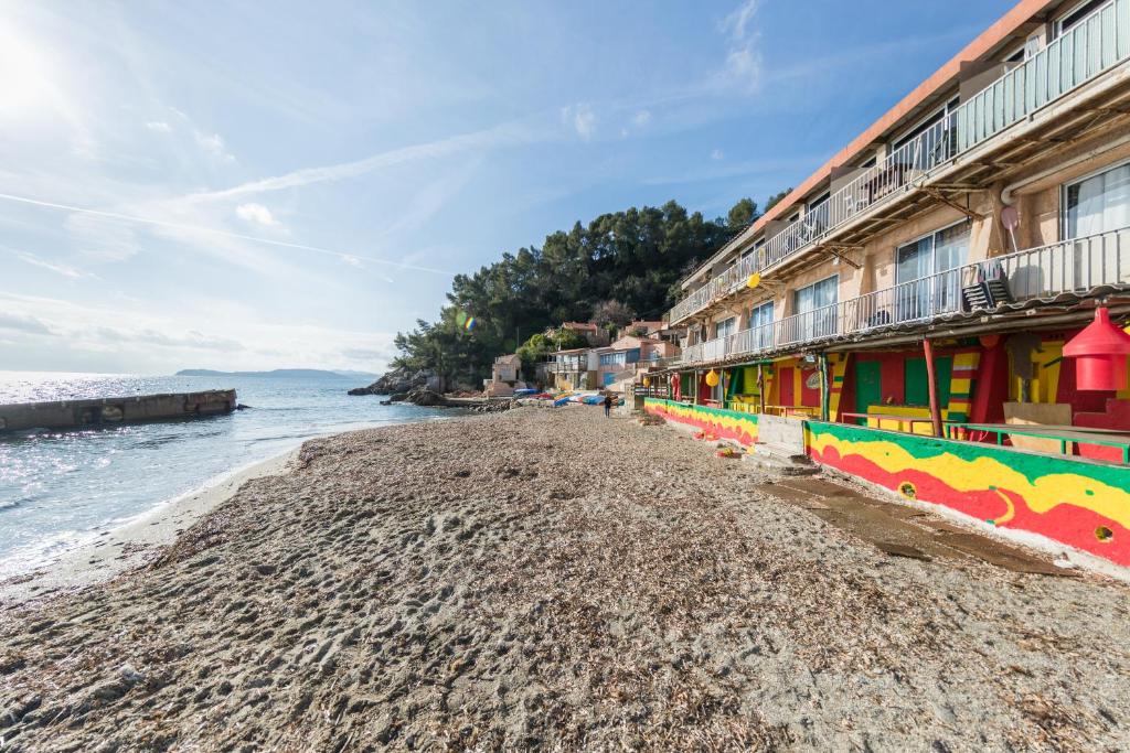 a beach with colorful buildings next to the water at Appartement Les Elfes in Le Pradet