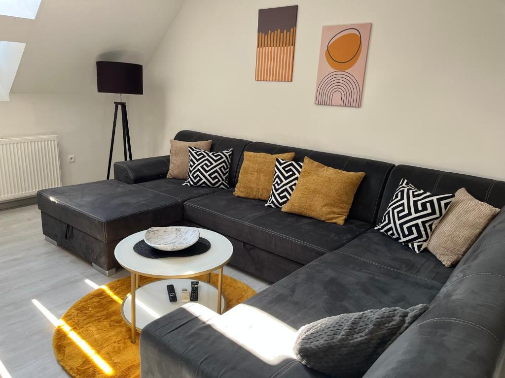 a living room with a black couch and a table at Apartment AFRODITA Trnava - Historic centre in Trnava