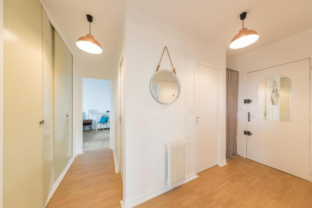 a hallway with white walls and a mirror at Appartement Les Elfes in Le Pradet