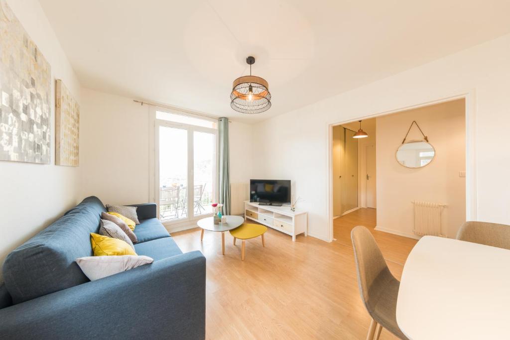 a living room with a blue couch and a tv at Appartement Les Elfes in Le Pradet