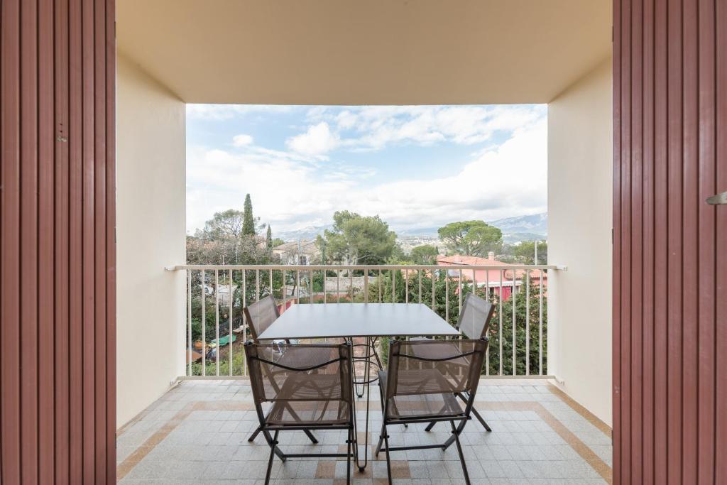 a patio with a table and chairs on a balcony at Appartement Les Elfes in Le Pradet
