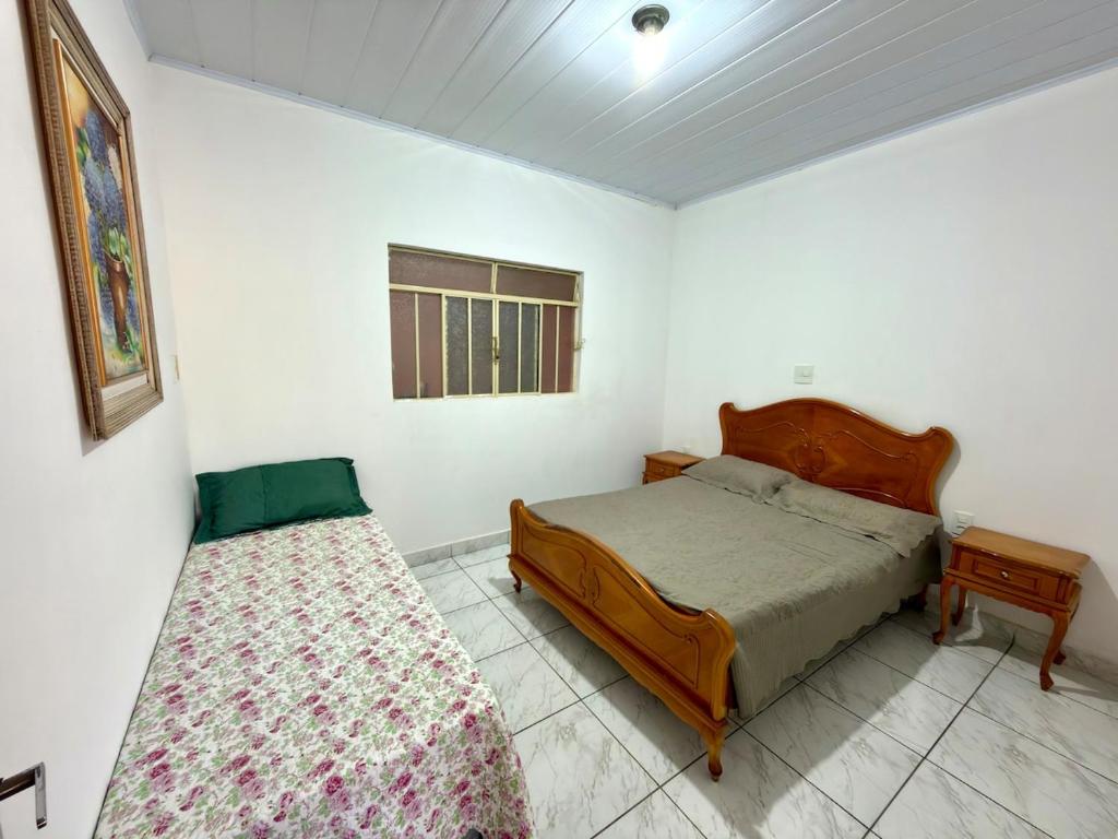 a bedroom with two beds and a window at Casa central, com 2 quartos e até 2 carros in Divinópolis