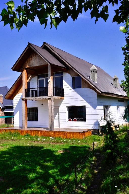 a white house with a gambrel roof at VELORA-DOODHPATHRi in Aphit