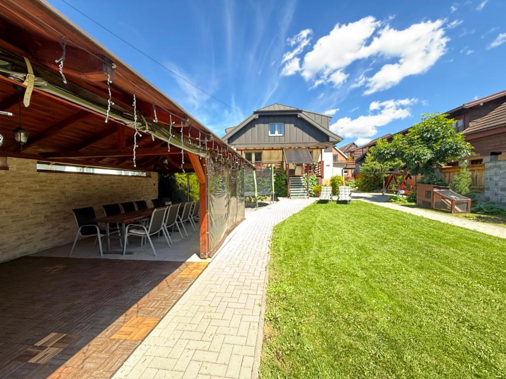 an outdoor patio with a table and chairs at Chalupa GABO pre 15 osôb in Habovka