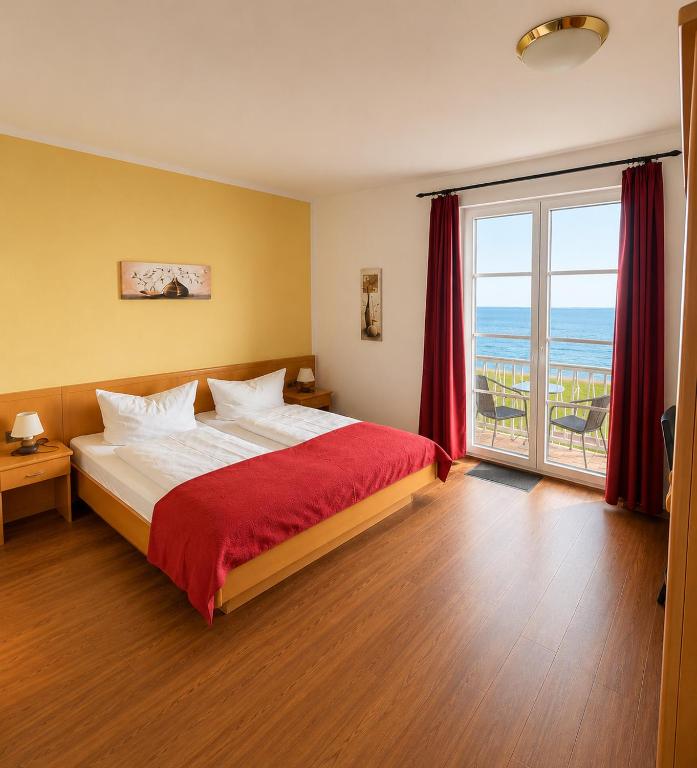 a bedroom with a bed with a view of the ocean at Hotel Seerose in Wilhelmshaven
