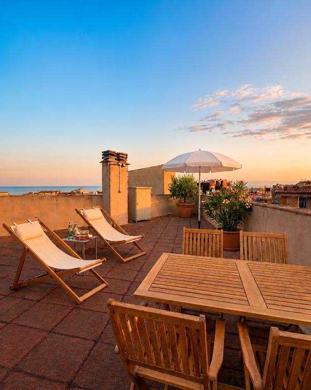 a patio with a table and chairs and an umbrella at LAttic Reserva BiosferaTerres de lEbre in Sant Carles de la Ràpita