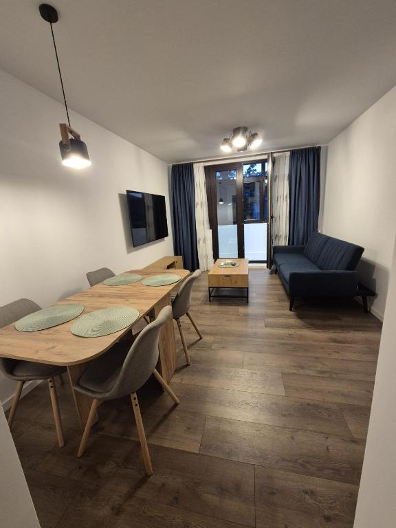 a living room with a table and chairs and a couch at The Garden Apartment in Bîrlad