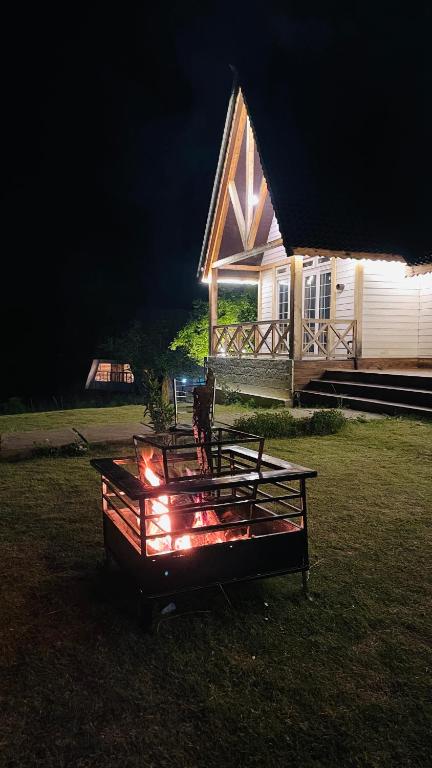 ein Haus mit einem Tisch davor, vor dem Lichter stehen in der Unterkunft CEDARS Resorts - Doodhpathri Kashmir in Rengazabal