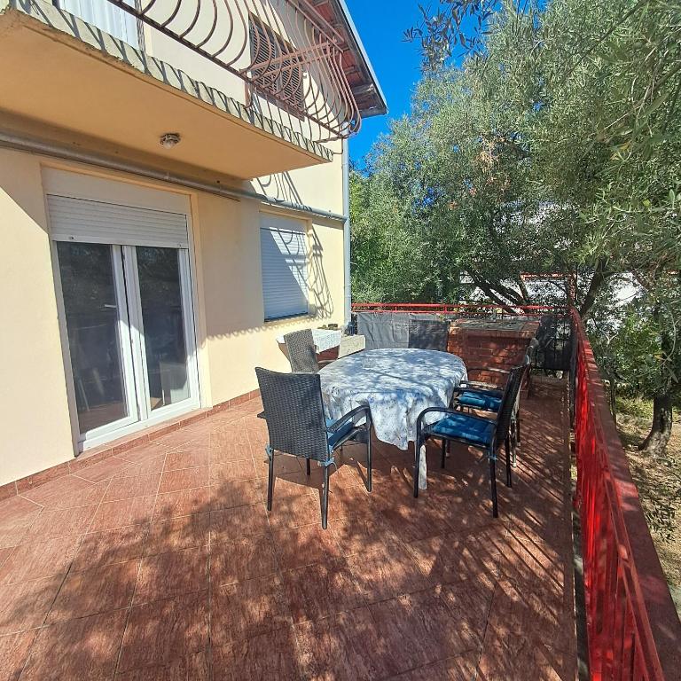 a patio with a table and chairs on a house at Kuća među maslinama s pogledom na more in Poljana