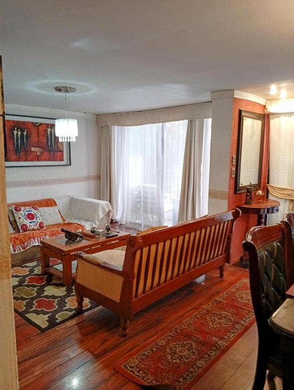 a living room with a couch and a table at Casa 3 dormitorios estacionamiento Heriberto Ortiz in Santiago