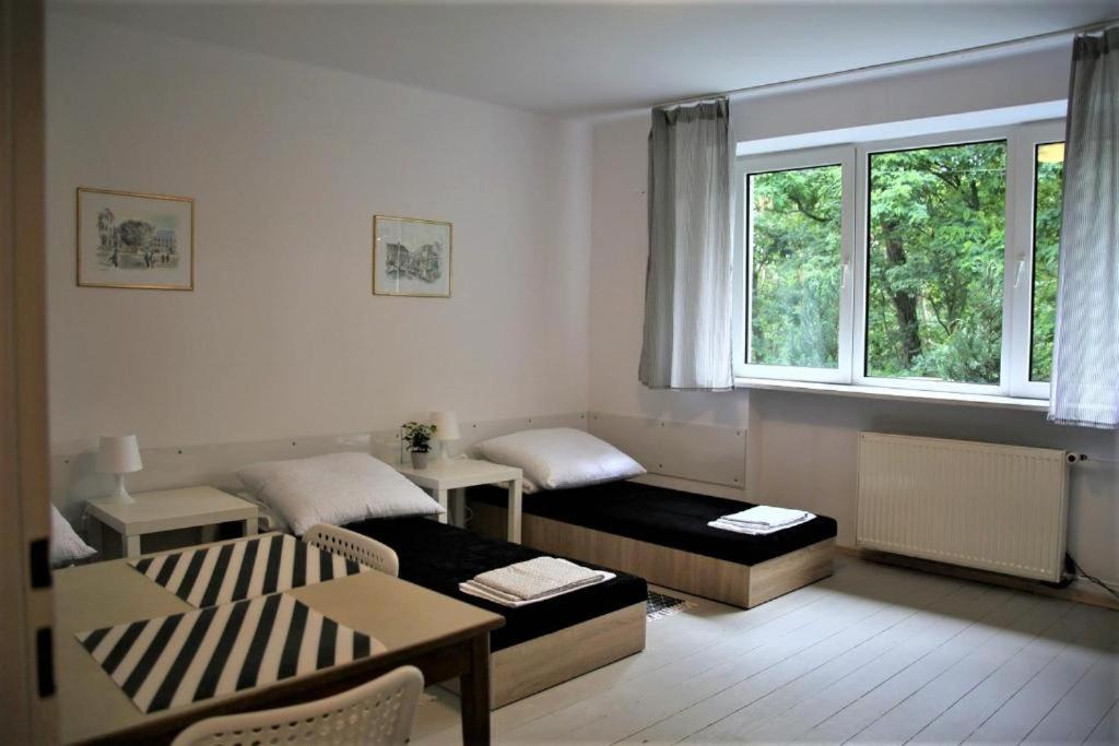 a living room with two beds and a window at TanieSpanie in Legionowo