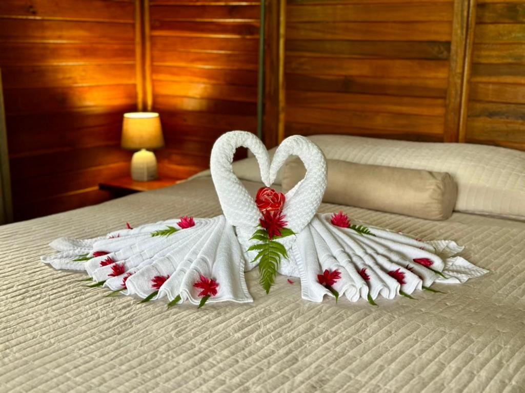 two swans made out of towels on a bed at Cabañas Los Laguitos Rio Celeste in El Achiote