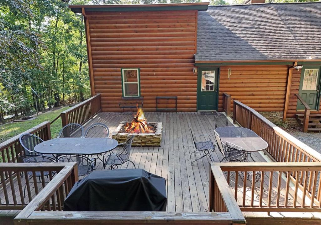 a deck with tables and chairs and a fire pit at S'more Waggin' Cabin: Pet-Friendly--wifi, firepit, pool table in Blue Ridge