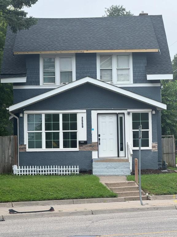 a blue house with a white door and a porch at Cozy Broadway in Minneapolis