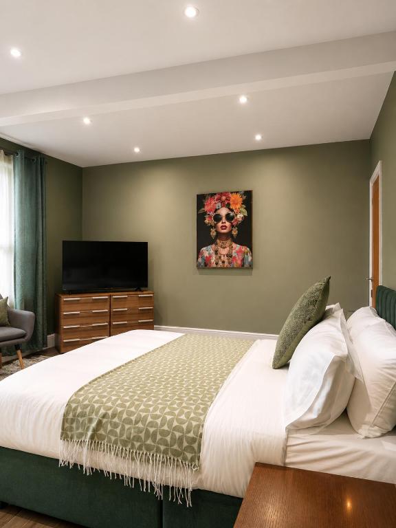 a bedroom with a large bed and a television at The Promenade House in New Brighton