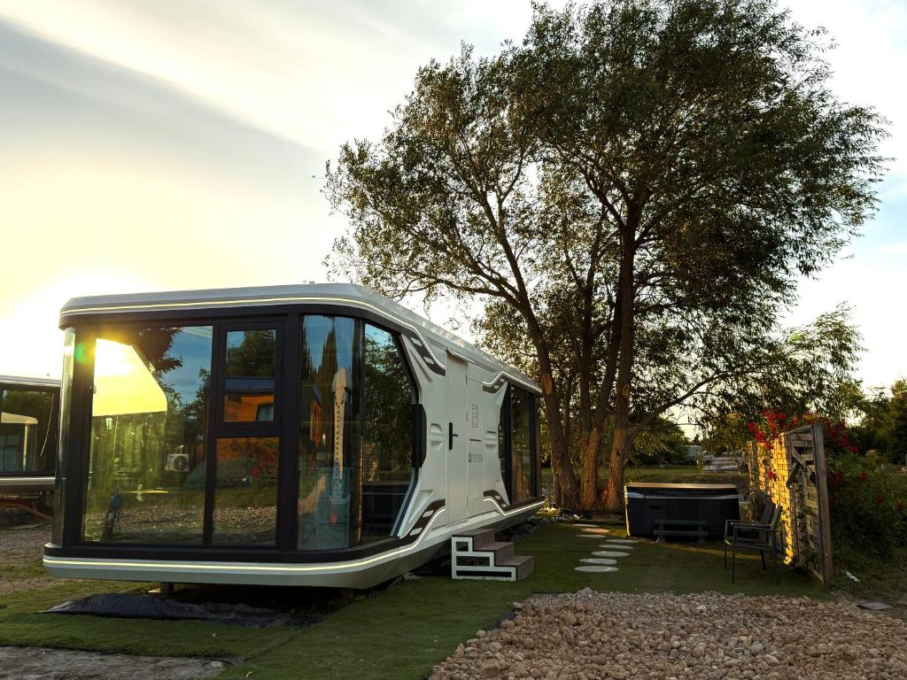 a black and white trailer parked next to a tree at Futuristic Capsule - Private Jacuzzi & Beach access in Wapnica