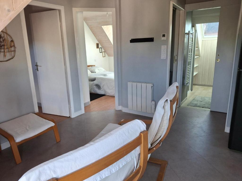 a living room with two chairs and a bedroom at Entre Terre et Mer in Malestroit