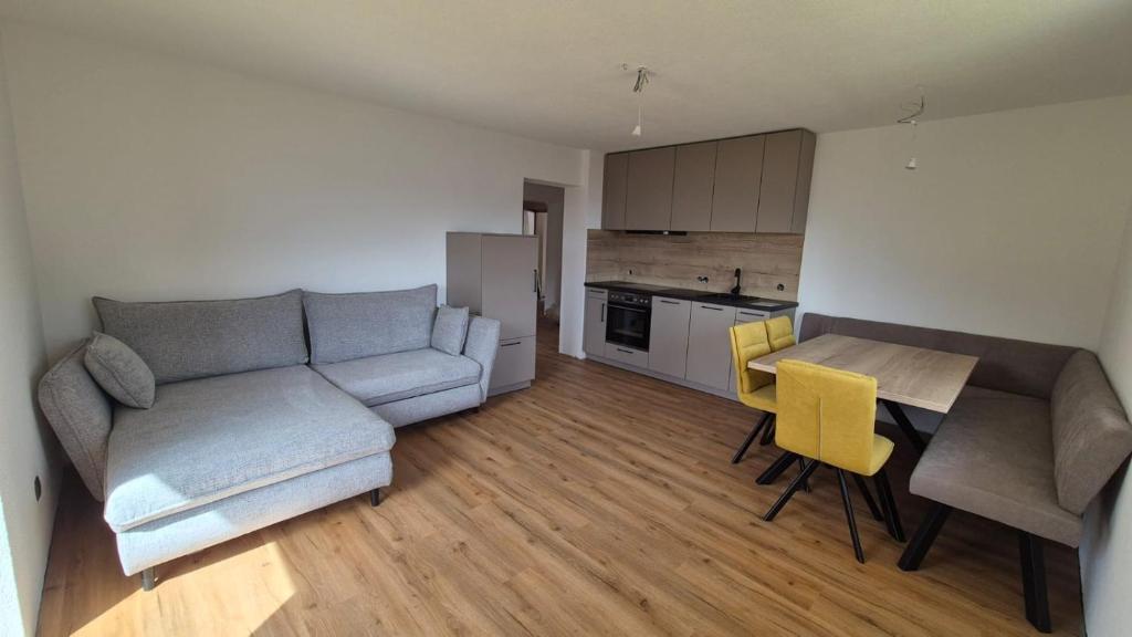 a living room with a couch and a table and yellow chairs at Hof am Berg in Kaunerberg