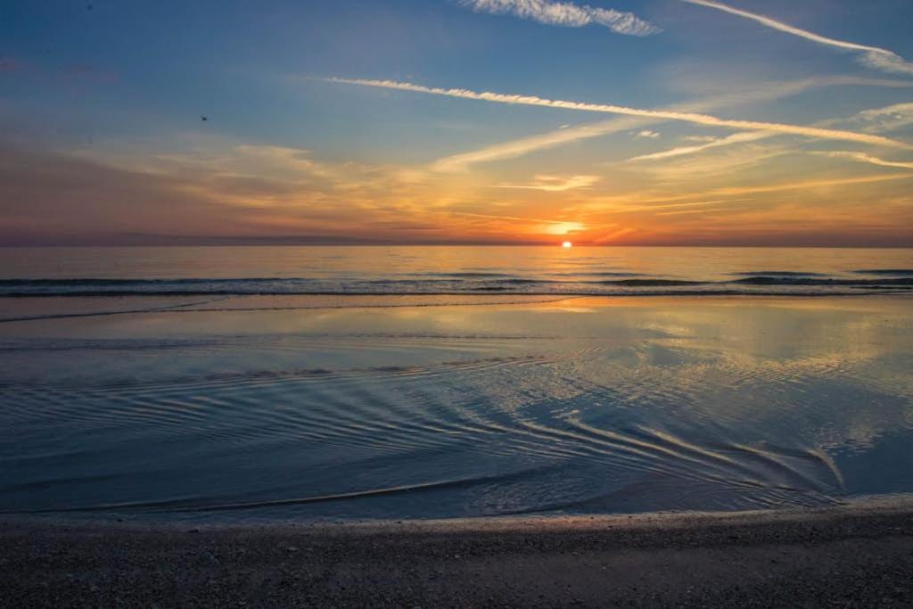 a sunset on a beach with the ocean at Palm Gables 106 in Holmes Beach