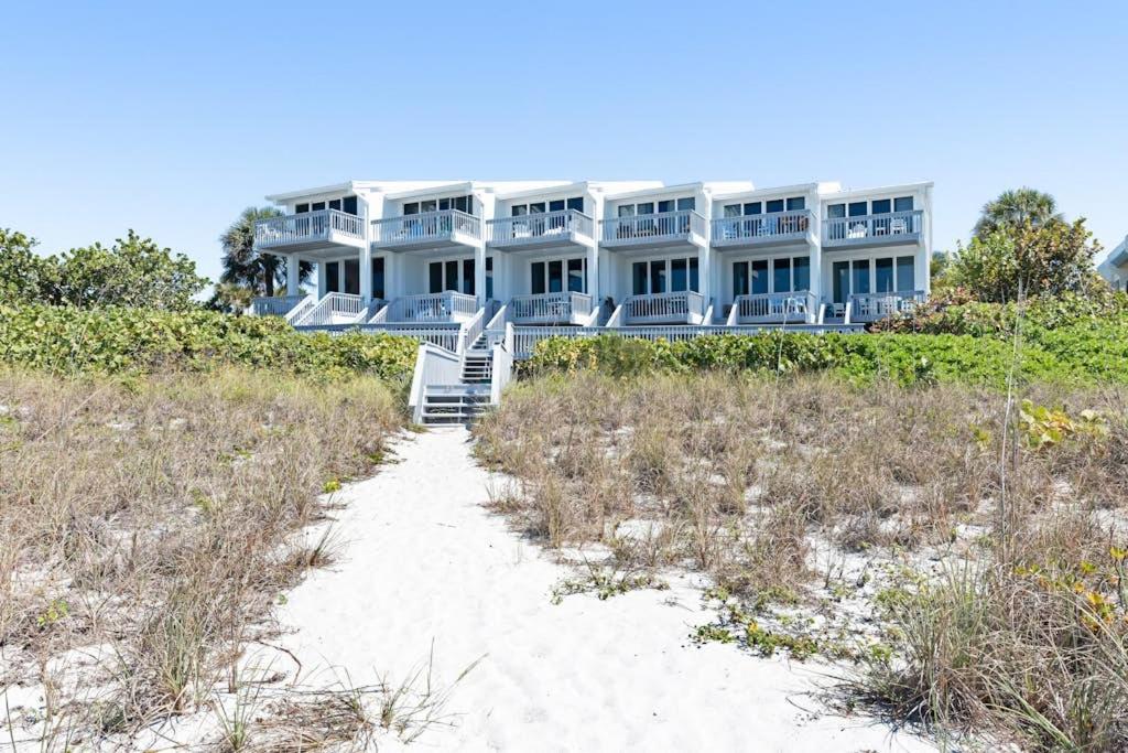 a large house on the beach with a sand path at Hidden Cove Unit 6 in Holmes Beach