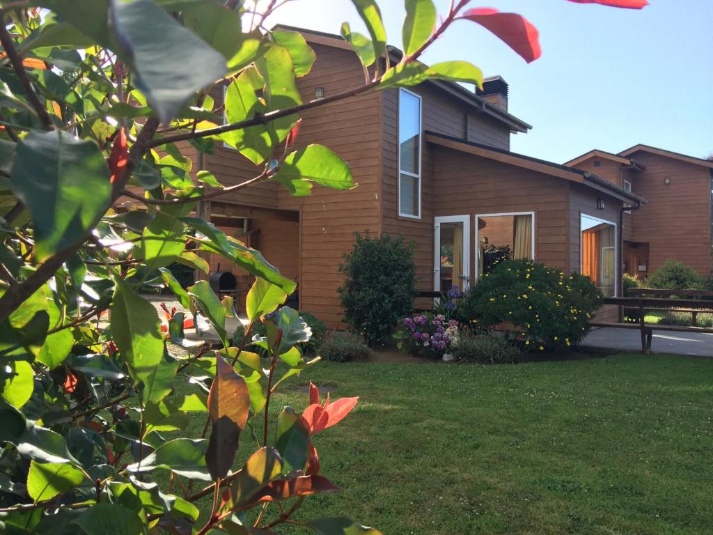 a house with a yard in front of it at Cabañas Portal de las Rosas in Puerto Varas