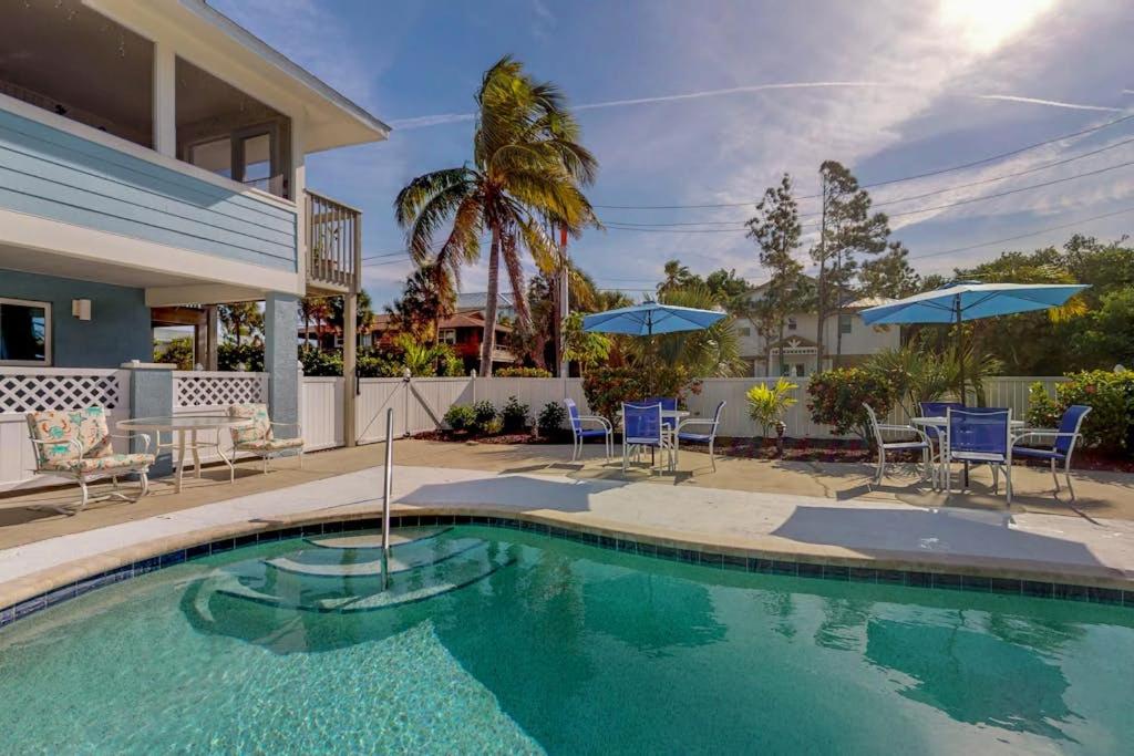 a house with a swimming pool with chairs and umbrellas at South Bay Inn 1 in Anna Maria