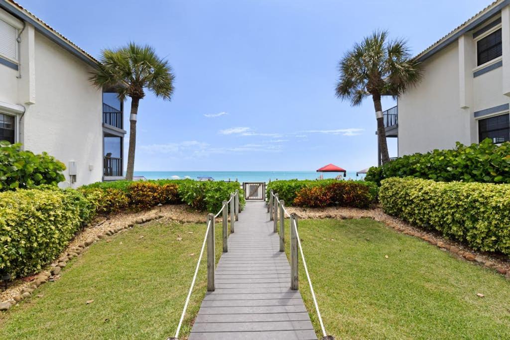 a walkway leading to the beach with palm trees at Gulf Place 19 in Holmes Beach