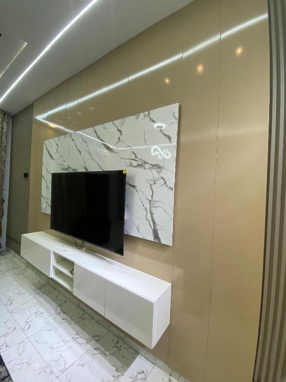 a flat screen tv sitting on top of a wall at Emilomo Luxury Apartment in Idowu