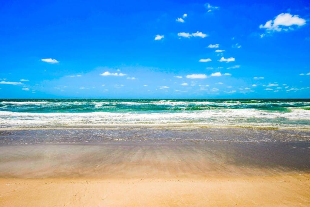 a beach with the ocean and the waves at Shortboard in Holmes Beach
