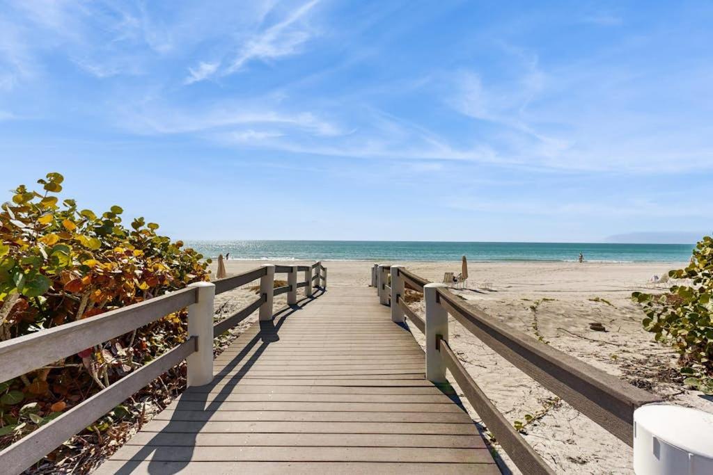 a wooden boardwalk leading to a beach with the ocean at Island Time Hideaway in Longboat Key