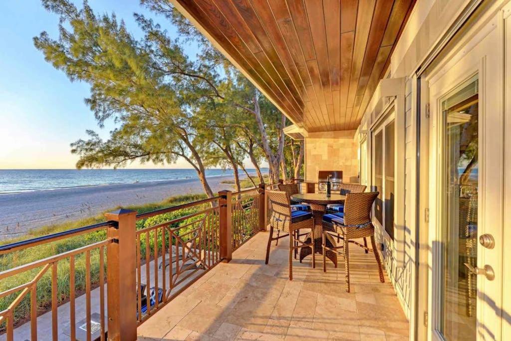 a porch with a table and chairs on the beach at Wine Down in Ilexhurst