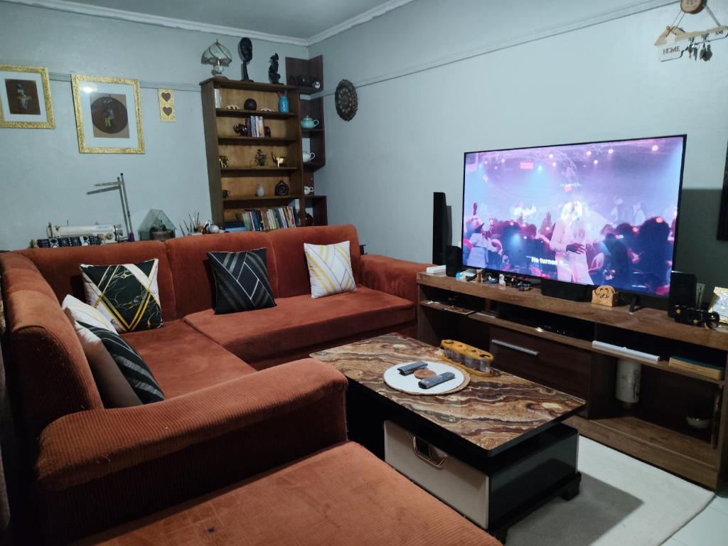 a living room with a couch and a flat screen tv at Victorious place in Kitale
