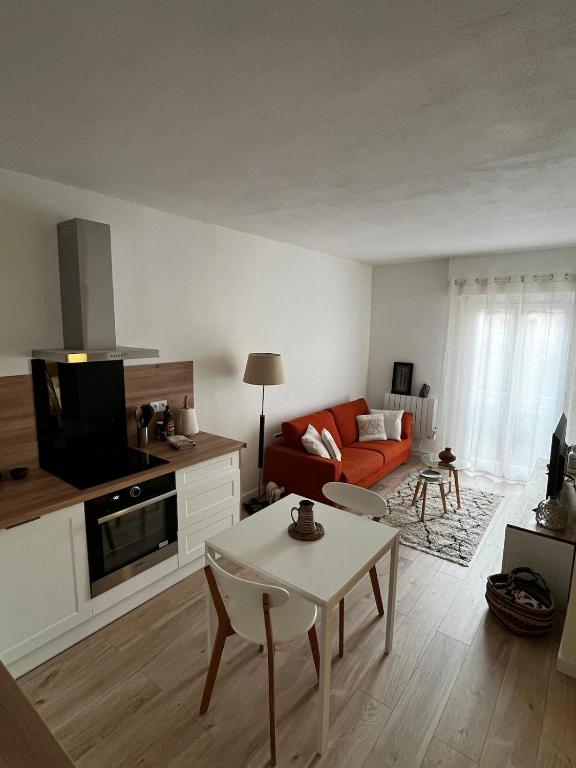 a living room with a couch and a tv at Céret hyper centre - Cozy T2 in Céret