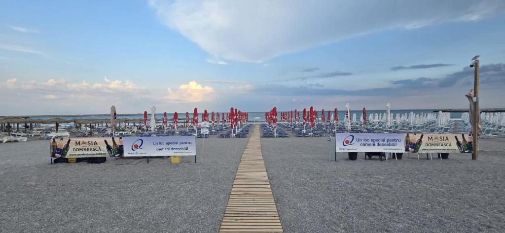 a row of signs on a sandy beach with boats at Hotel Sunquest in Venus