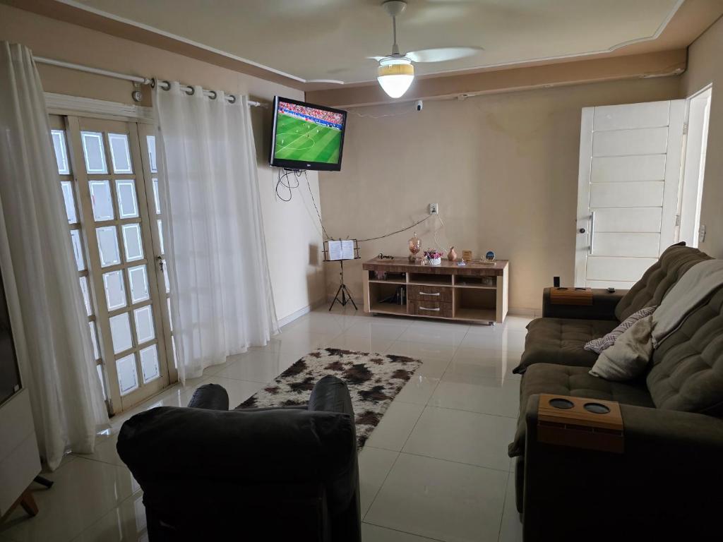 a living room with a couch and a flat screen tv at momento de paz in Sumaré