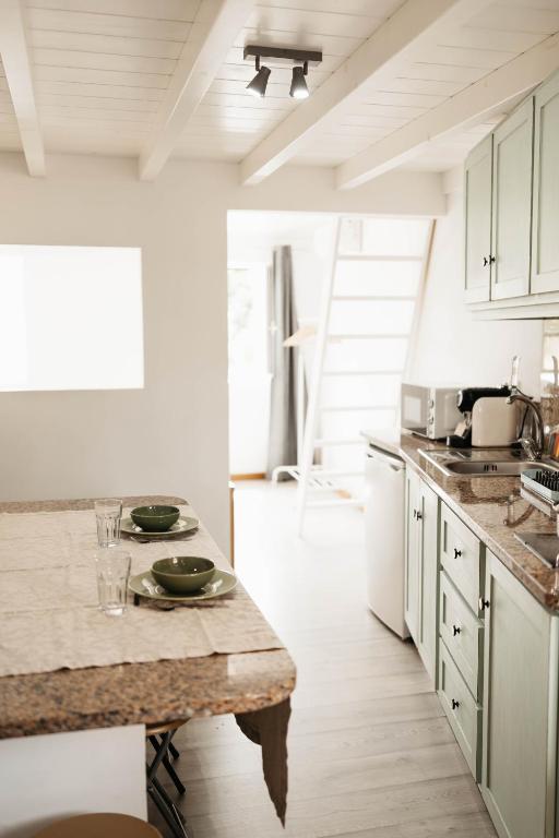 a kitchen with white cabinets and a marble counter top at Casa do Foral by Lethes Legacy in Ponte de Lima