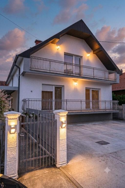 a white house with a fence in front of it at Modex ROOMS in Paraćin