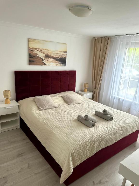 a bedroom with a large bed with two towels on it at Błękitna Fala in Ustka