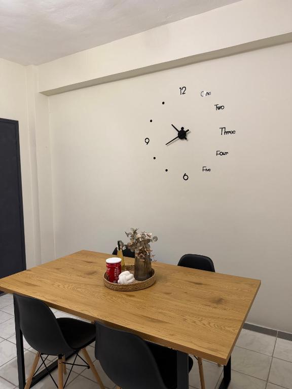 a wooden table with chairs and a clock on the wall at Sidari Centre Apartments in Sidari