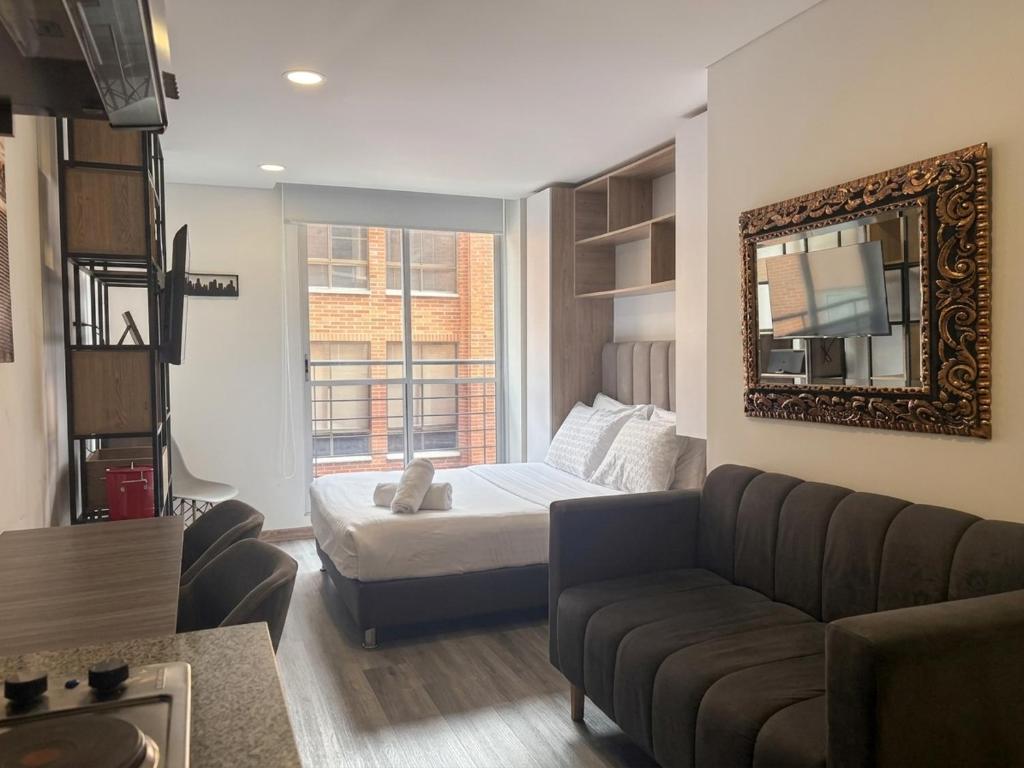 a living room with a bed and a couch at Parque de La 93 - Elite Flats in Bogotá