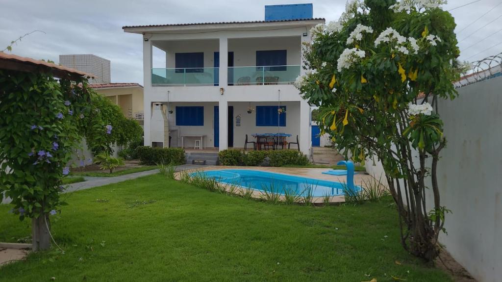 a house with a swimming pool in the yard at Casa Estrela Azul in Pitimbu