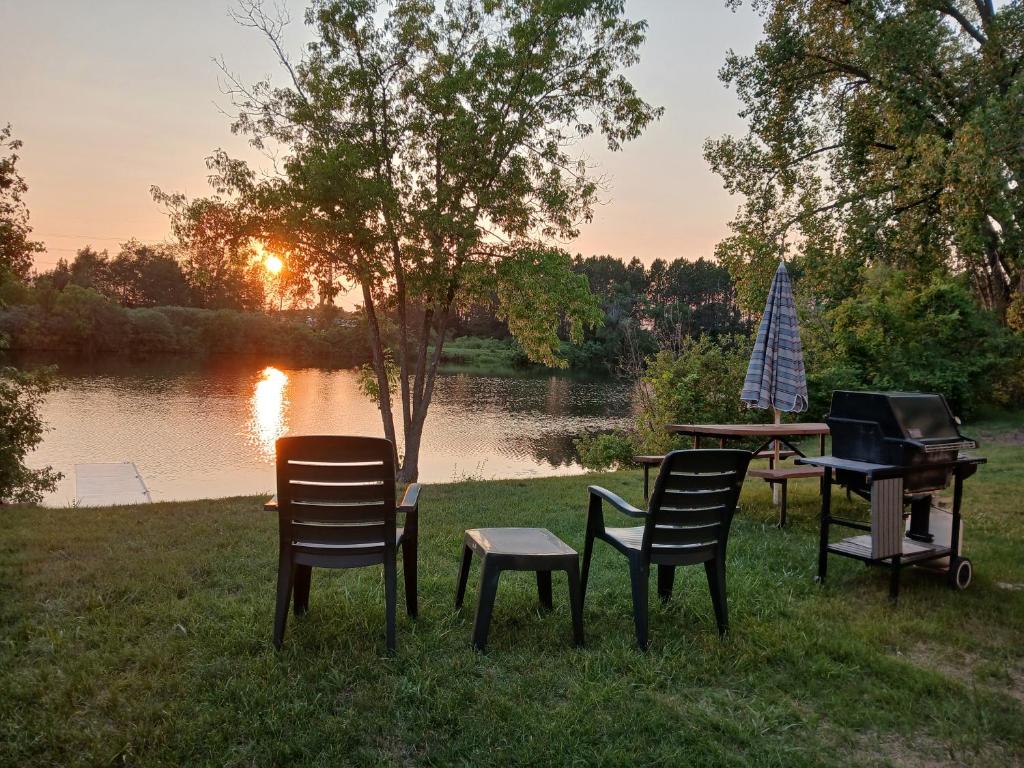 a group of chairs and a grill next to a lake at Back Bay Getaway in Hayward